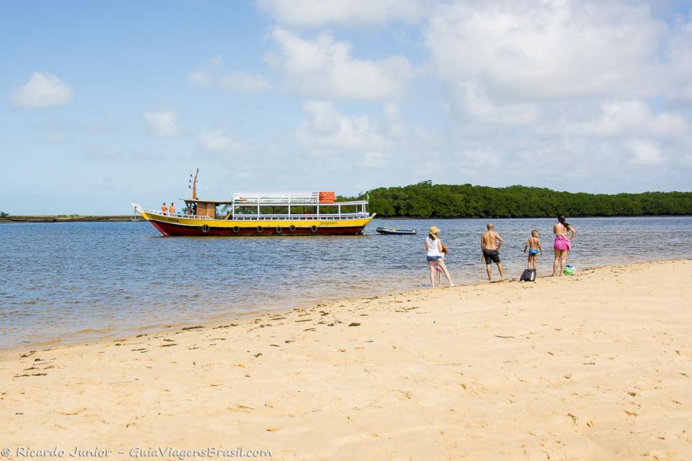 Imagem de pessoas vendo o a chegada do barcos de passeio.